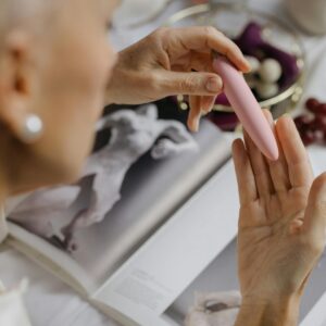 A woman holding a pink vibrator.