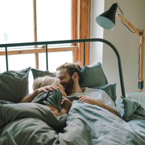 A couple  haring an intimate moment in bed.