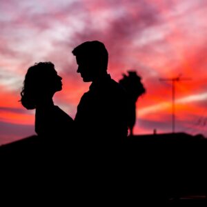 A couple  looking into each other's eyes in the sunset. 